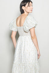 woman wearing a floral print puff sleeve maxi dress with a smocked bodice and tiered skirt, shown from the back