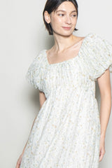 woman wearing a light floral print puff sleeve dress with a square neckline