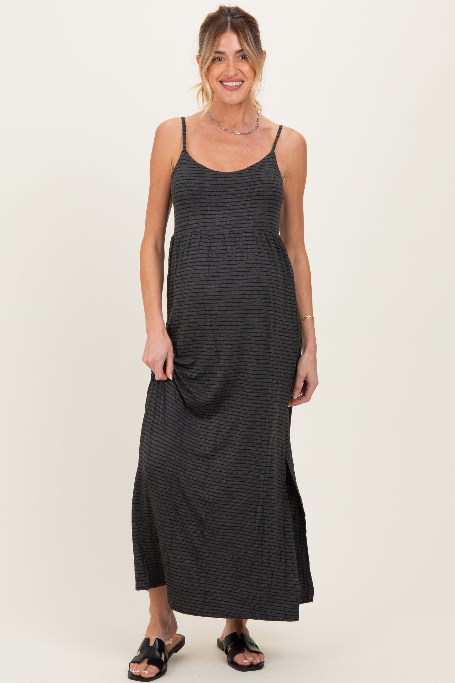 woman wearing a black and gray striped maternity maxi dress with spaghetti straps and a relaxed fit