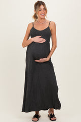 woman wearing a black striped maternity maxi dress and holding her baby bump