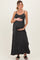 woman wearing a black striped maternity maxi dress and holding her baby bump