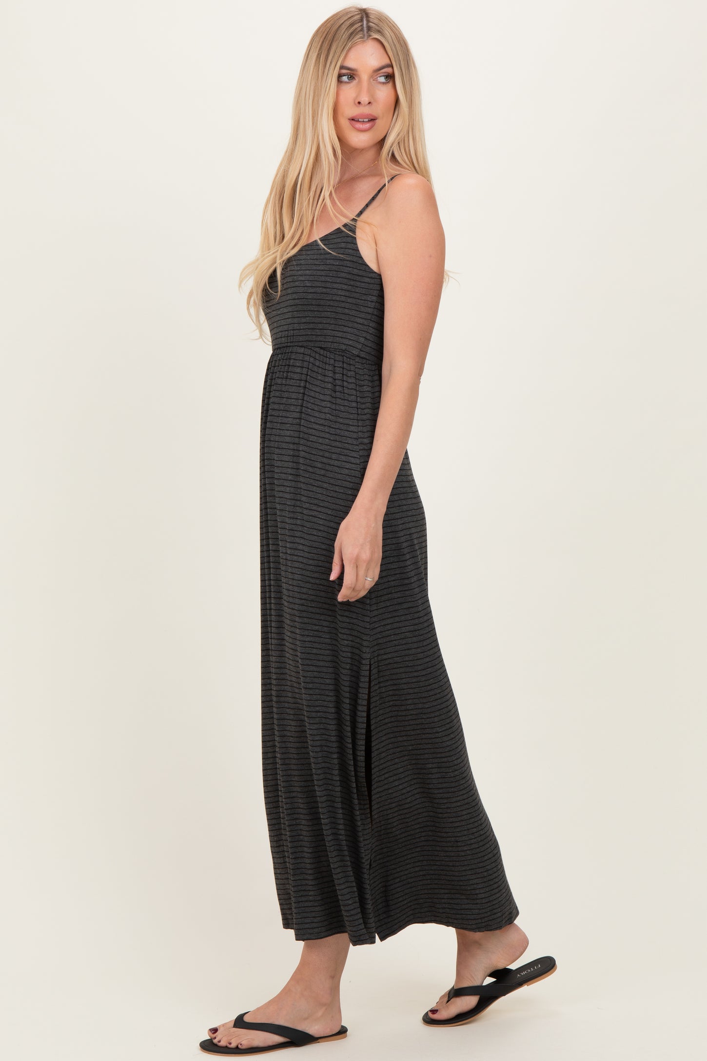 woman wearing a black and gray striped maxi dress with spaghetti straps and a relaxed fit