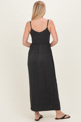woman wearing a black and gray striped maxi dress with adjustable straps and a cinched waist