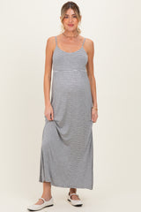 woman wearing a striped gray maternity maxi dress with adjustable straps and a relaxed fit, showing her baby bump