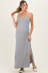 woman wearing a gray and white striped maternity maxi dress with a side slit and holding her hair up