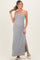 woman wearing a gray and white striped maternity maxi dress with a side slit and holding her hair up