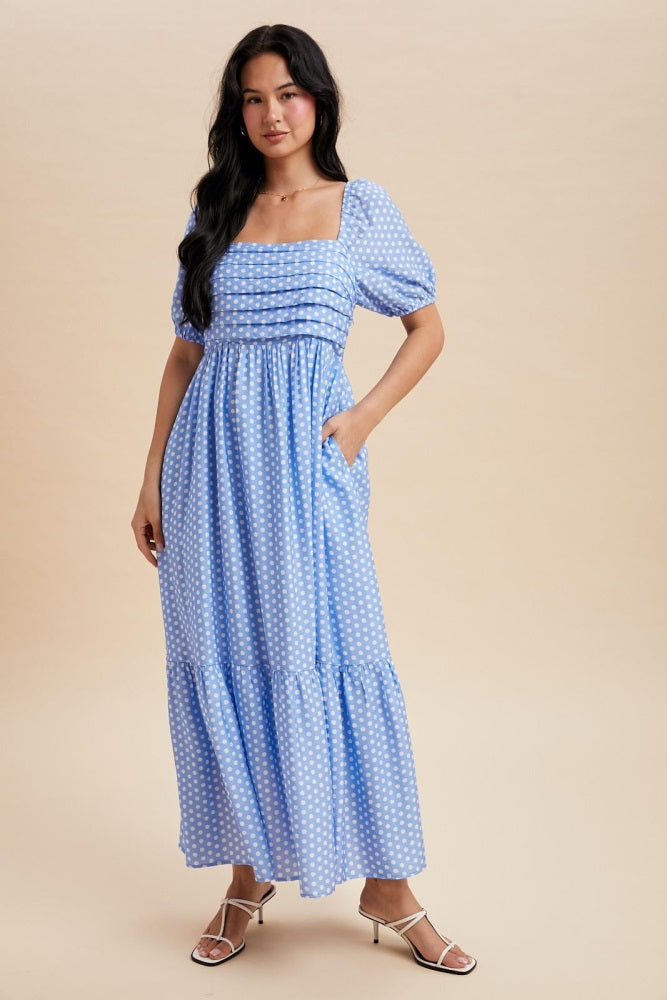 woman wearing a blue polka dot maxi dress with puff sleeves and pockets