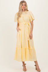woman wearing a yellow short sleeve midi dress with a tie waist and ruffle hem