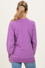 woman wearing a light purple maternity sweatshirt, seen from the back with a relaxed fit and ribbed hem