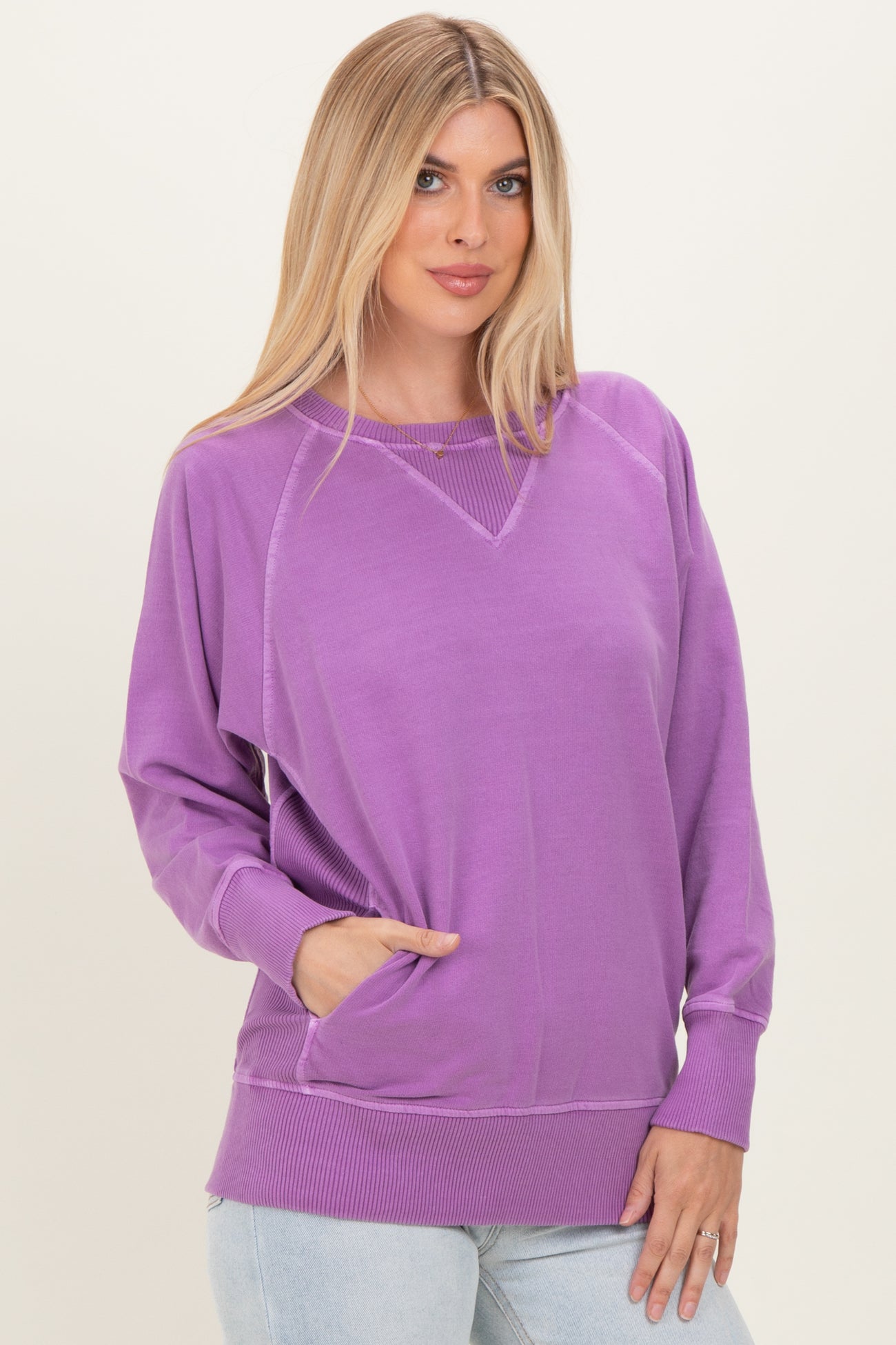 woman wearing a purple oversized sweatshirt with a v-neck and front pockets