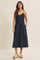 woman wearing a navy blue denim button-up midi dress with thin straps and side pockets