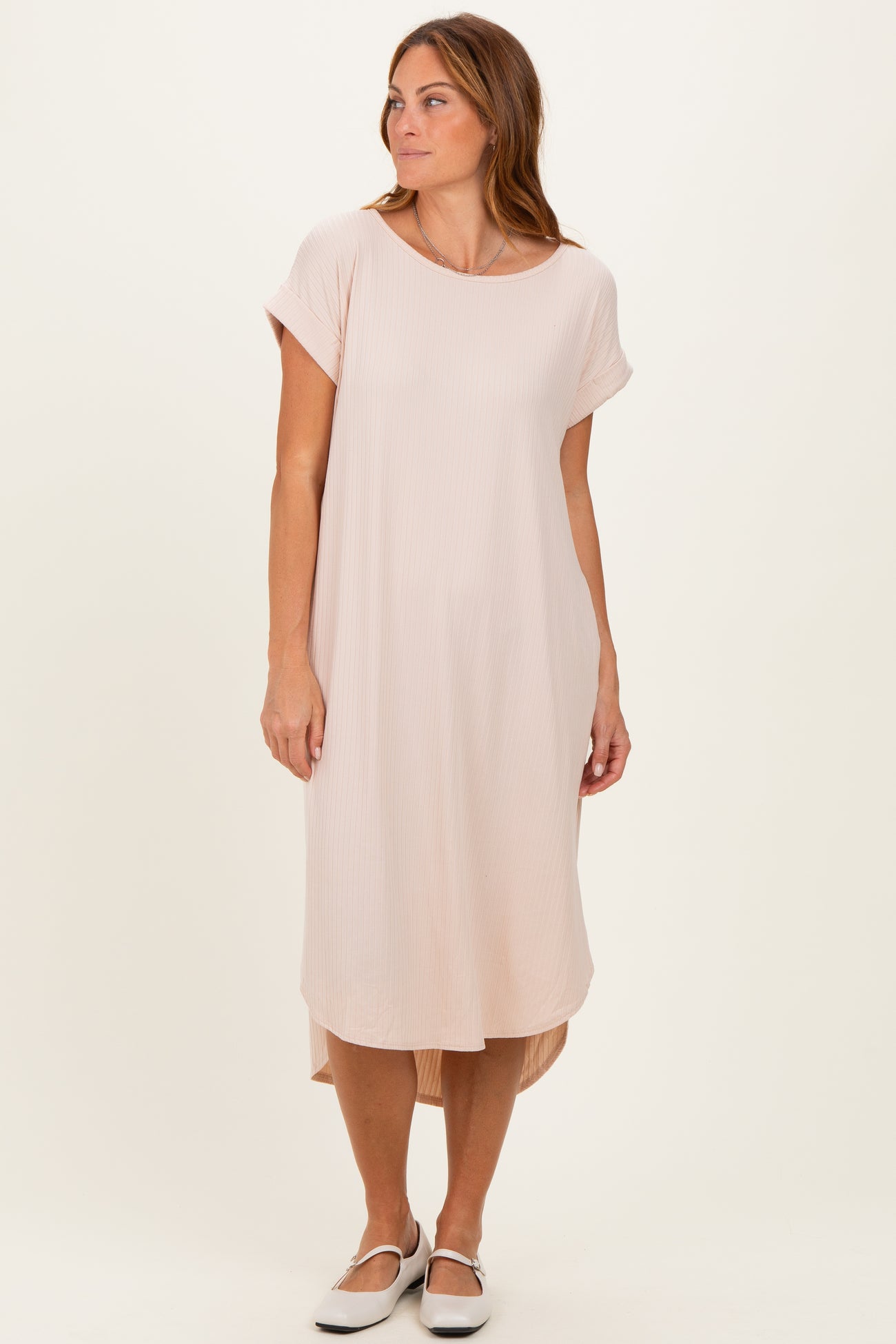 woman wearing a light pink short sleeve midi dress with a flowing silhouette and a high-low hemline