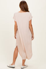 woman wearing a light pink maxi dress with short sleeves and side slits, shown from the back