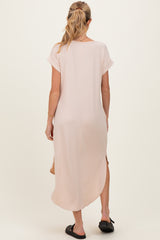 woman wearing a light pink long sleeve maternity dress with side slits, view from the back