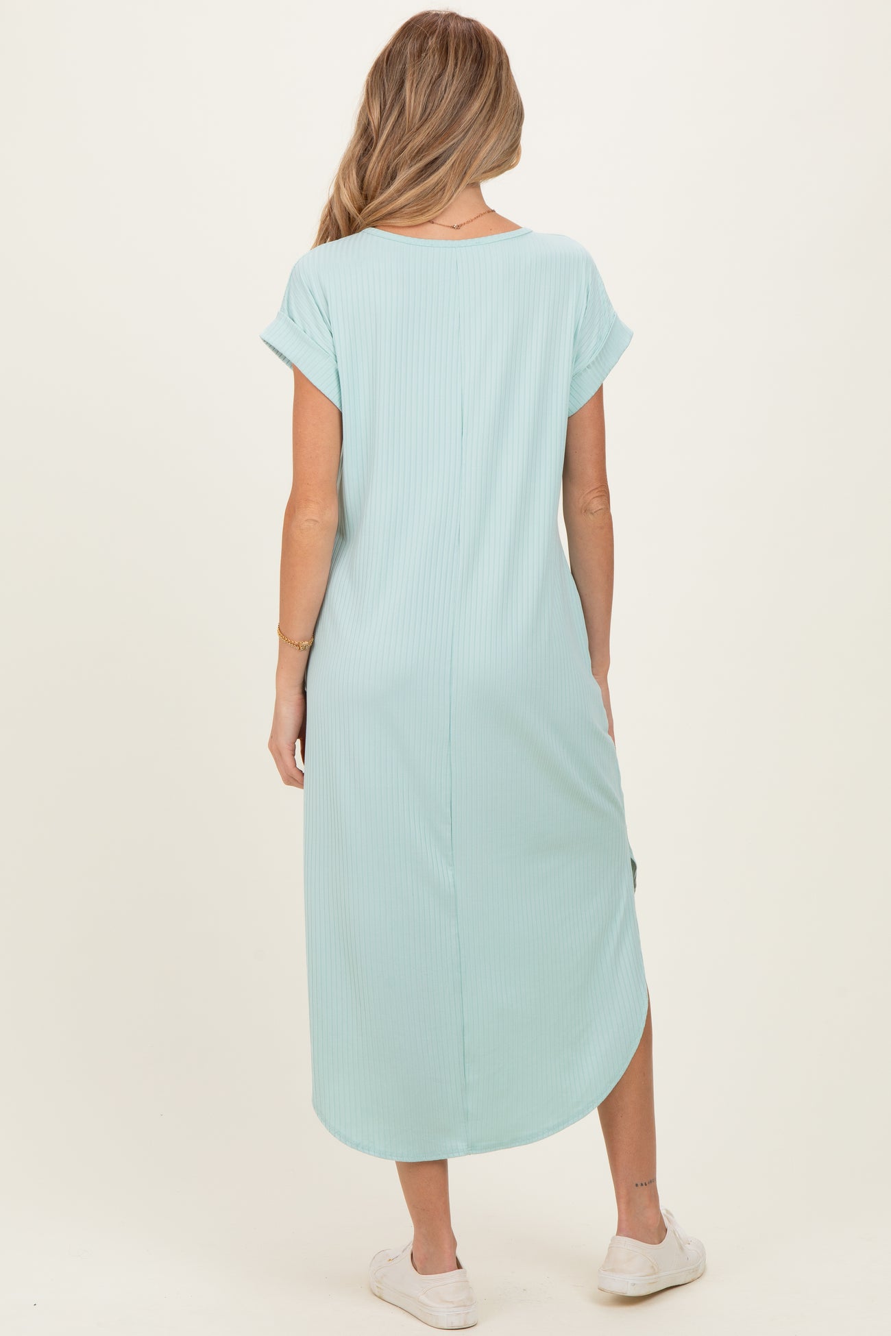 woman wearing a mint green maternity maxi dress with short sleeves and side slits, showing her back