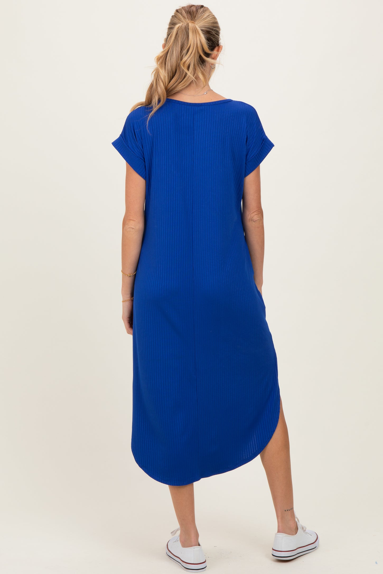 woman wearing a royal blue maternity dress with short sleeves and a high-low hem, seen from the back
