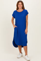 woman wearing a blue ribbed short sleeve midi dress with side pockets and a curved hemline