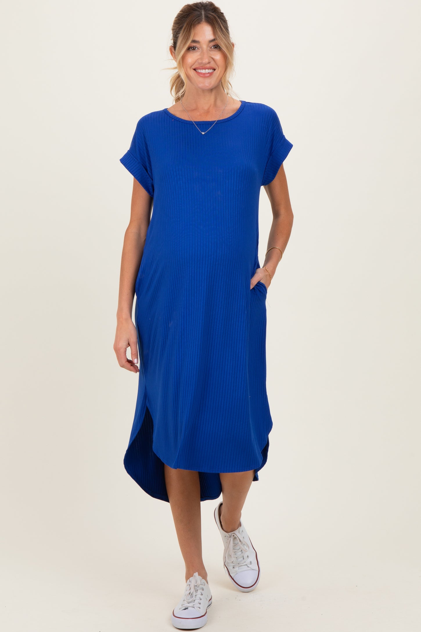 woman wearing a bright blue maternity maxi dress with short sleeves and pockets, showing her baby bump