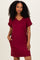 woman wearing a burgundy v-neck short sleeve dress with pockets and rolled cuffs