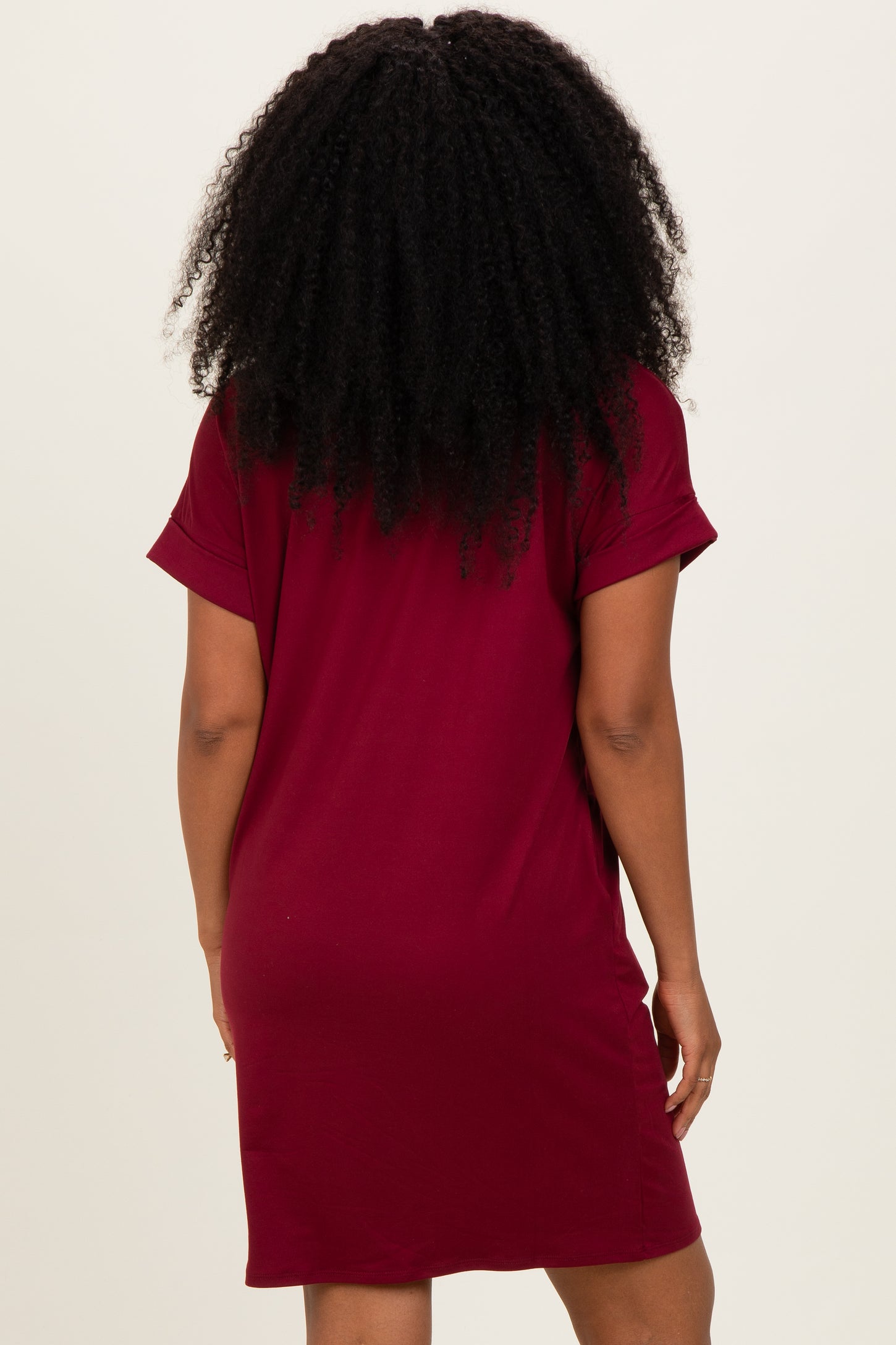 woman wearing a maroon short sleeve dress, shown from the back with a relaxed fit and above-the-knee length