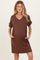 woman wearing a brown short sleeve v-neck maternity dress with side pockets and a visible baby bump