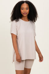 woman wearing a beige short sleeve tunic top paired with matching bike shorts