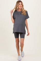 woman wearing a dark gray maternity tunic top and matching bike shorts, showing her baby bump