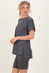 woman wearing a dark gray short sleeve athletic top and matching bike shorts, styled with a relaxed fit