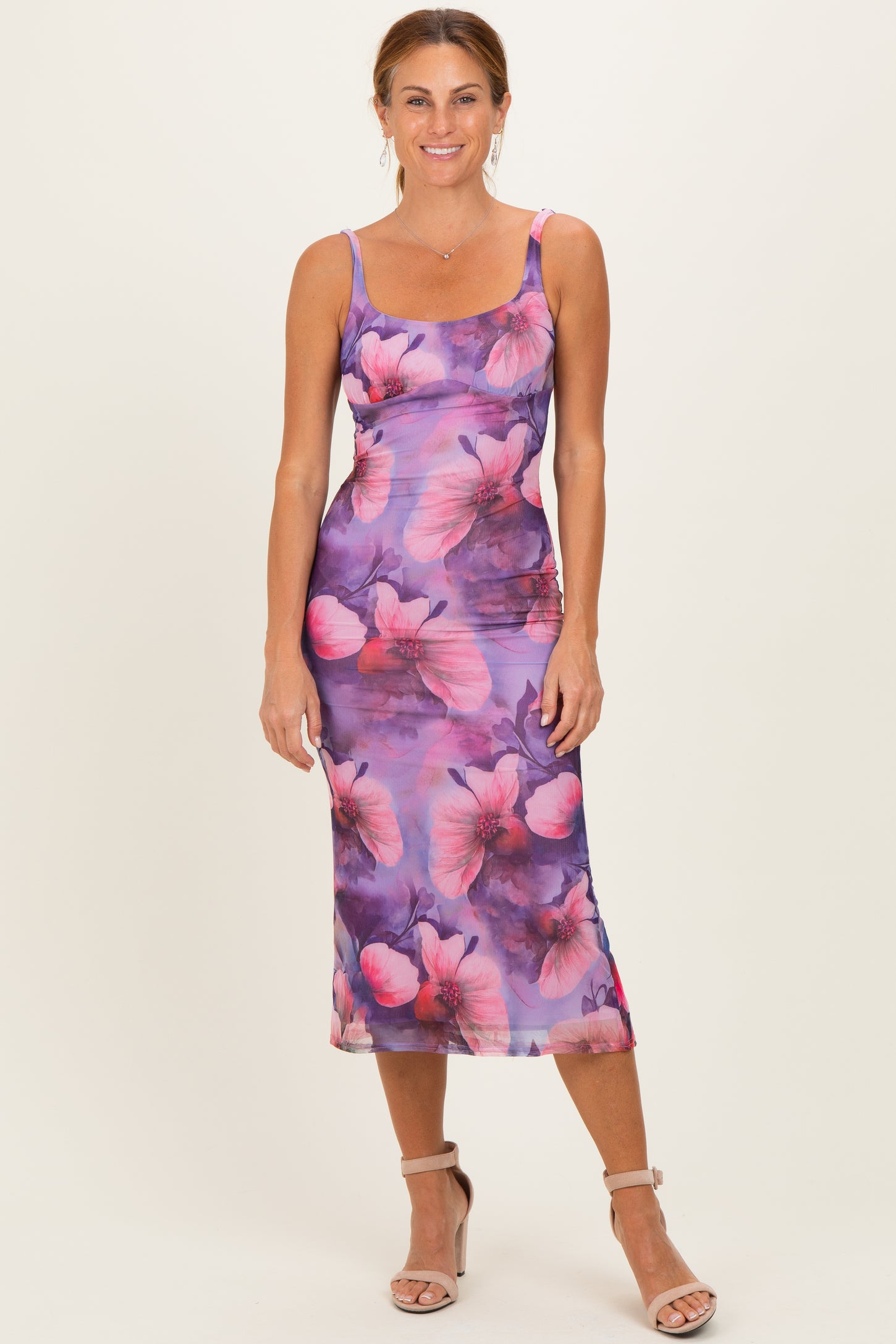 woman wearing a purple floral midi dress with slim straps and a fitted silhouette