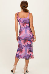 woman wearing a purple floral midi dress with butterfly prints and a fitted silhouette, seen from the back