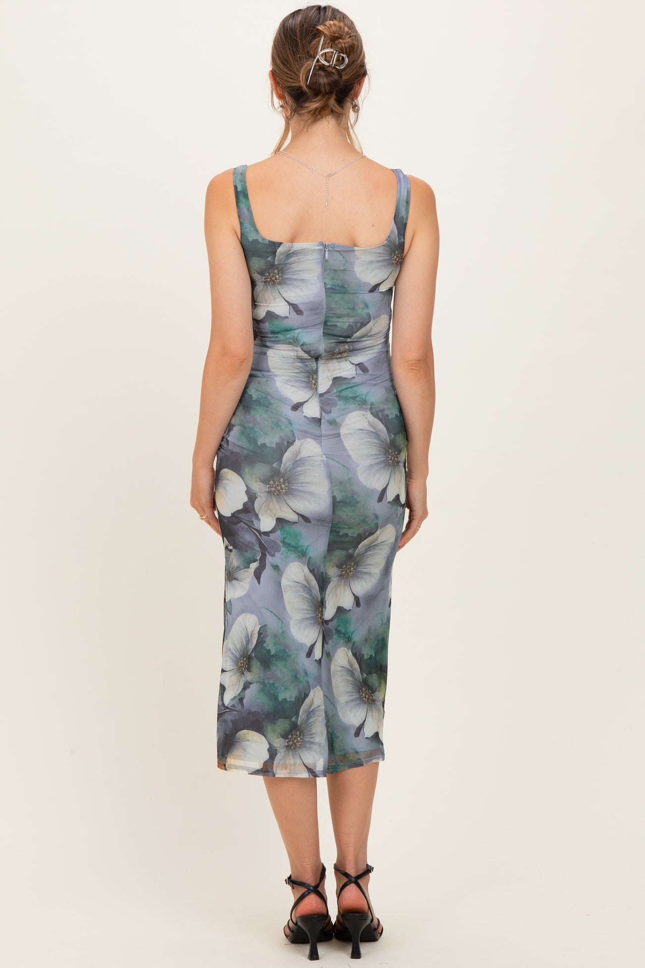 woman wearing a floral print maternity midi dress with a fitted silhouette and square neckline, viewed from the back