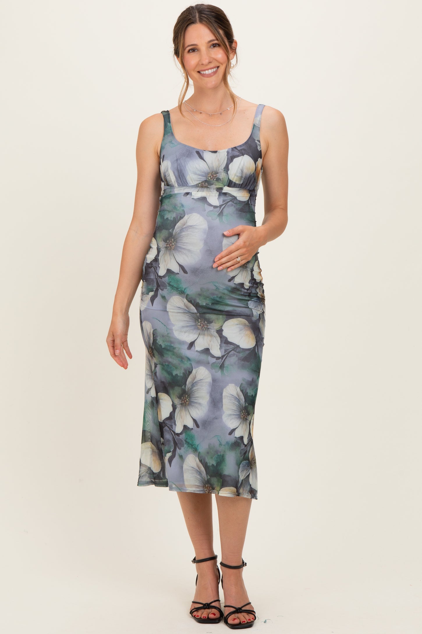 woman wearing a floral printed maternity dress with a fitted silhouette and a visible baby bump