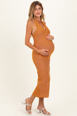 woman wearing a striped orange and yellow maternity dress, holding her baby bump