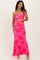 woman wearing a hot pink strapless maternity maxi dress with floral print and holding her baby bump