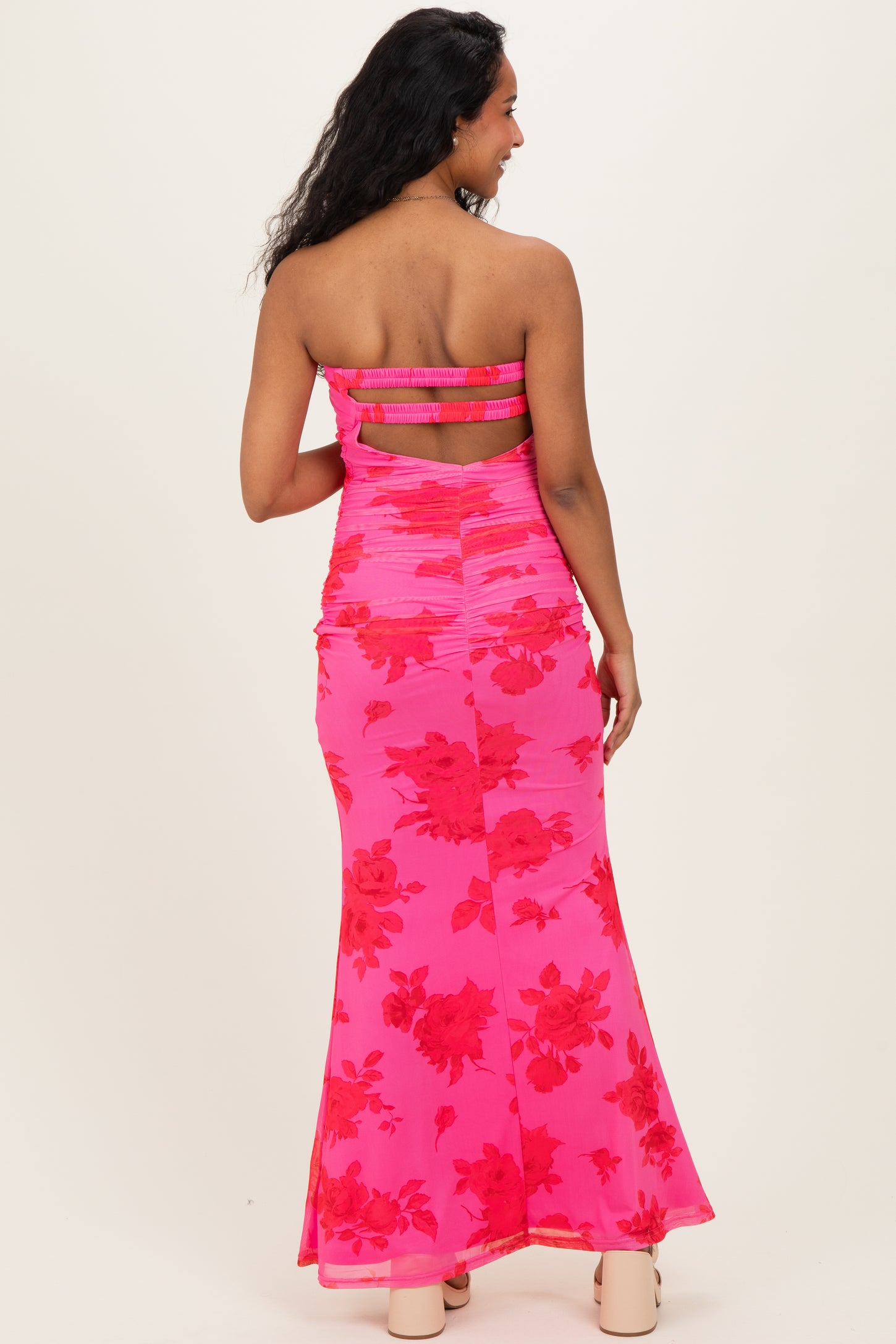 woman wearing a pink floral maternity maxi dress with a ruched design and strapless neckline