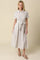 woman wearing a striped midi shirt dress with buttons and a tie waist, styled with flat shoes
