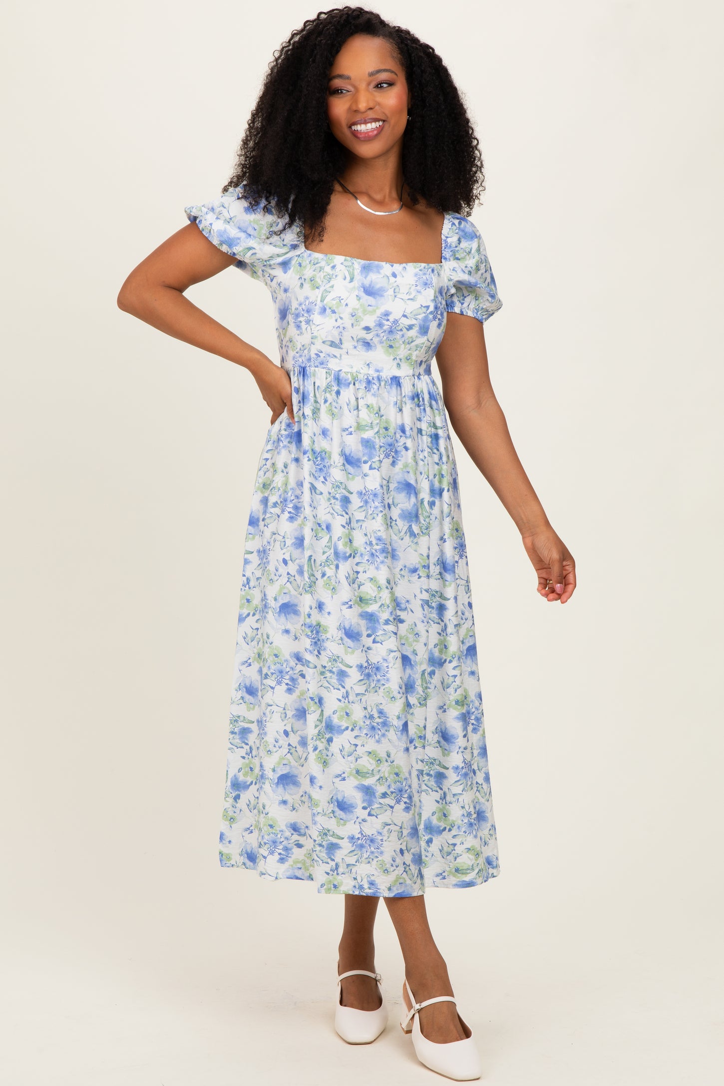 woman wearing a blue and white floral maxi dress with short sleeves and a square neckline