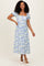 woman wearing a blue and white floral maxi dress with short sleeves and a square neckline