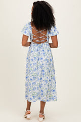 woman wearing a blue floral midi dress with a lace-up back and short puff sleeves