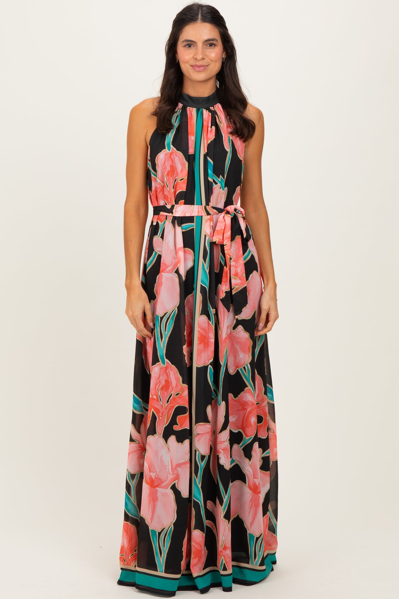 woman wearing a black floral maxi dress with pink flowers and a tie waist detail