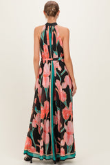 woman wearing a black floral maternity maxi dress with a halter neck and open back design