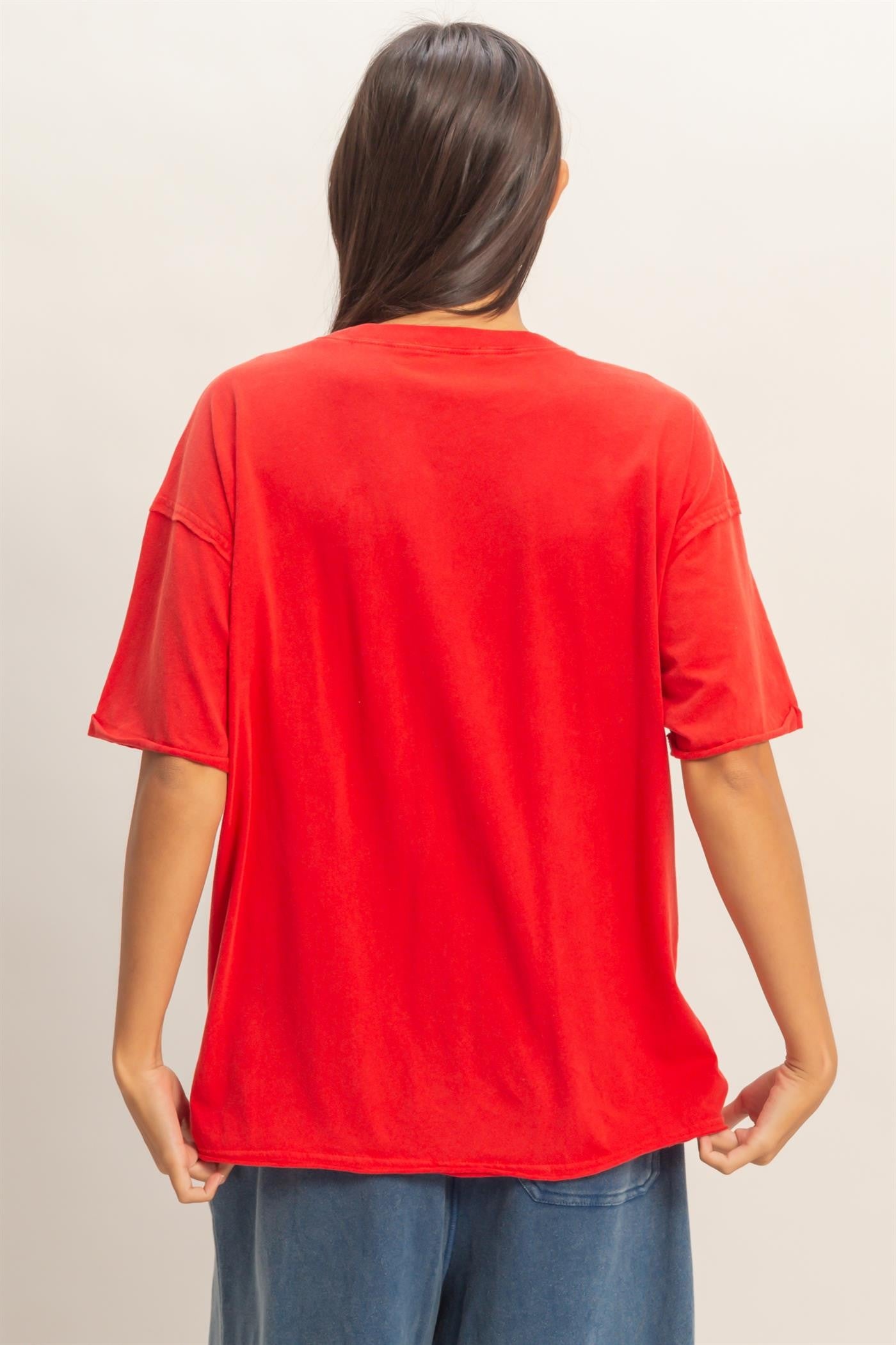 woman wearing a red oversized t-shirt, viewed from the back, paired with blue wide-leg pants
