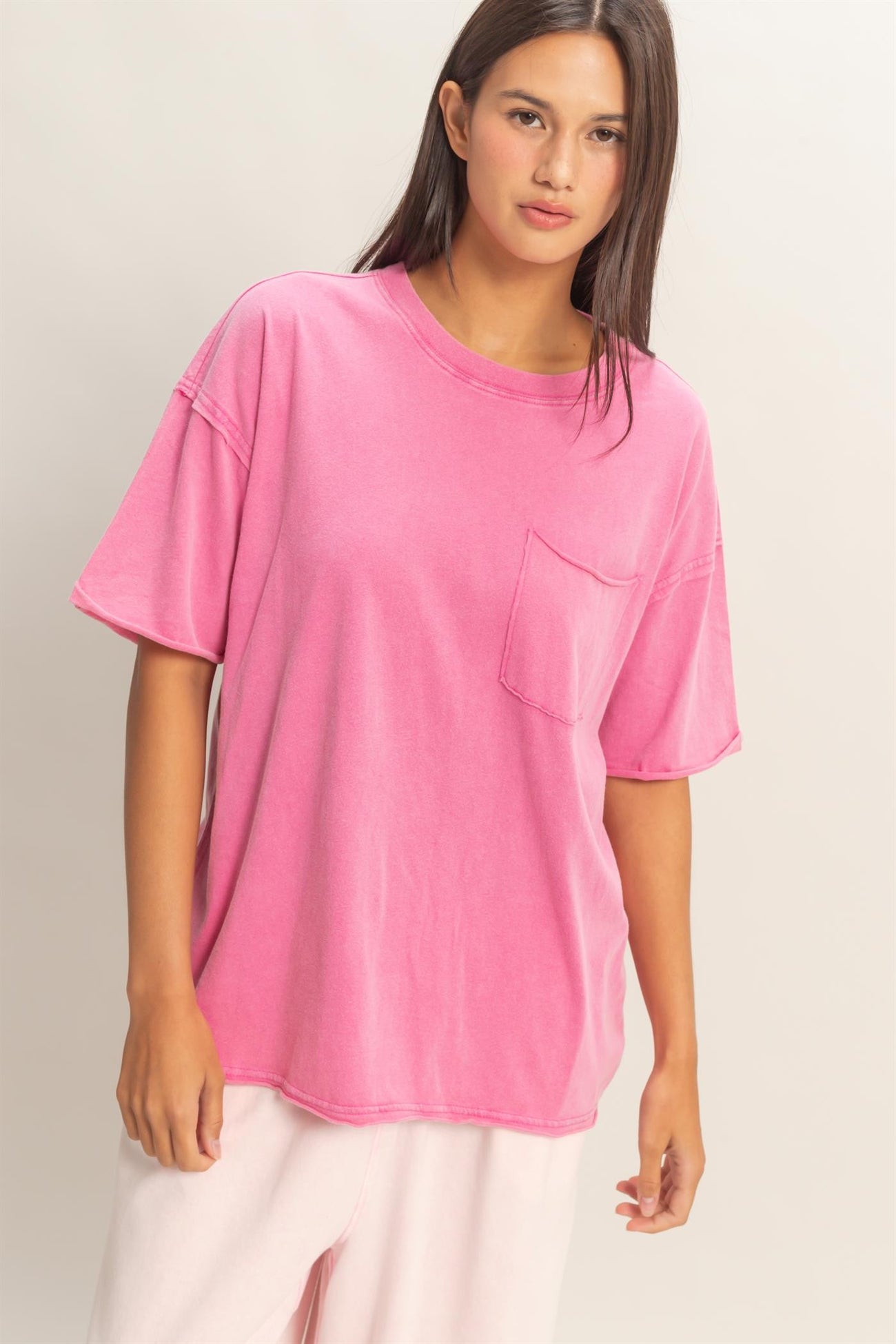 woman wearing a loose fit pink oversized t-shirt with a chest pocket