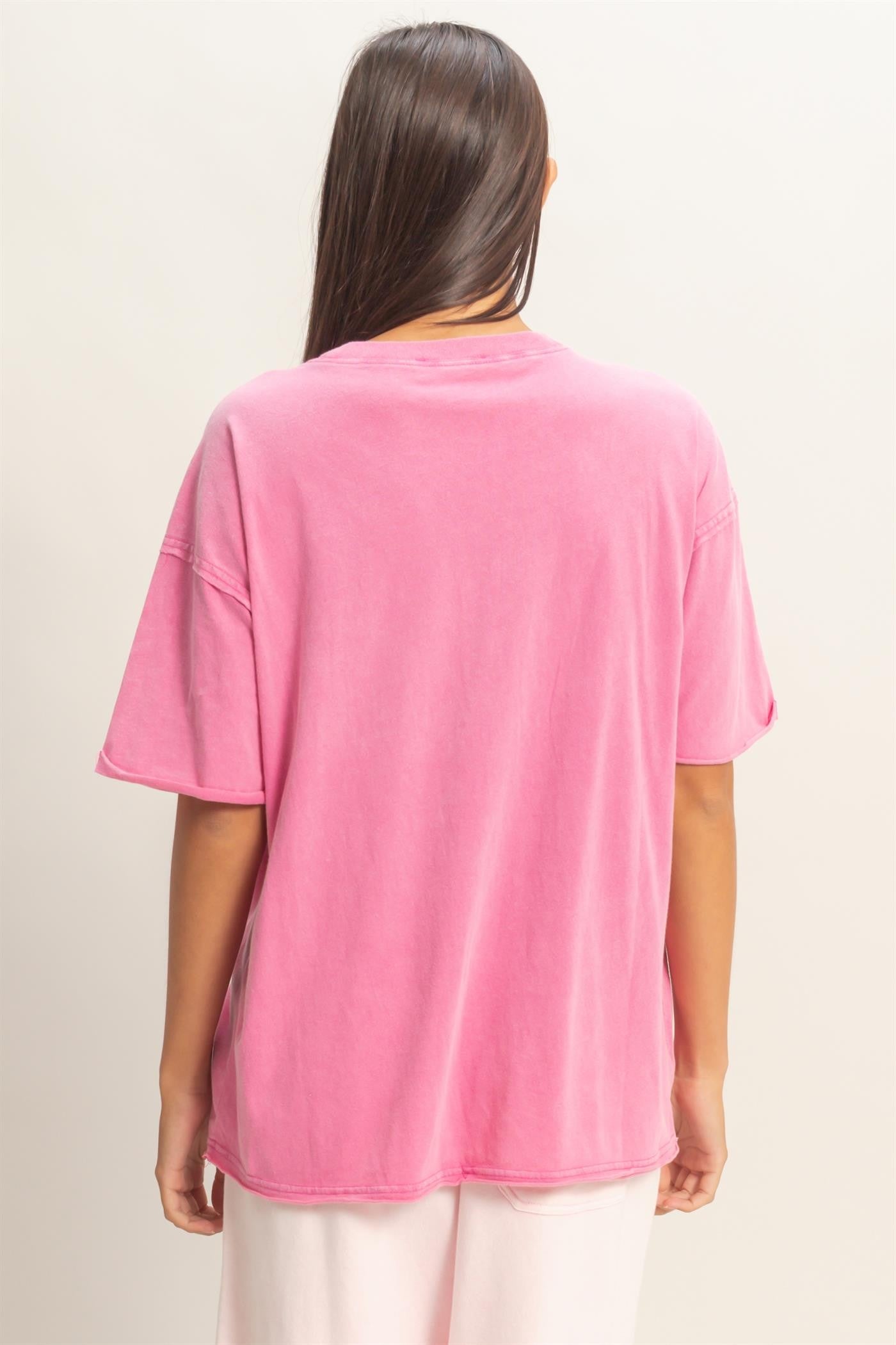 woman wearing a loose-fitting pink oversized t-shirt, seen from the back
