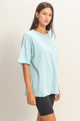 woman wearing a light blue oversized t-shirt with a pocket and black bike shorts