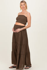 woman wearing a brown strapless maternity top and matching tiered maxi skirt, showing her baby bump