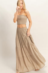 woman wearing a beige smocked crop top and matching tiered maxi skirt