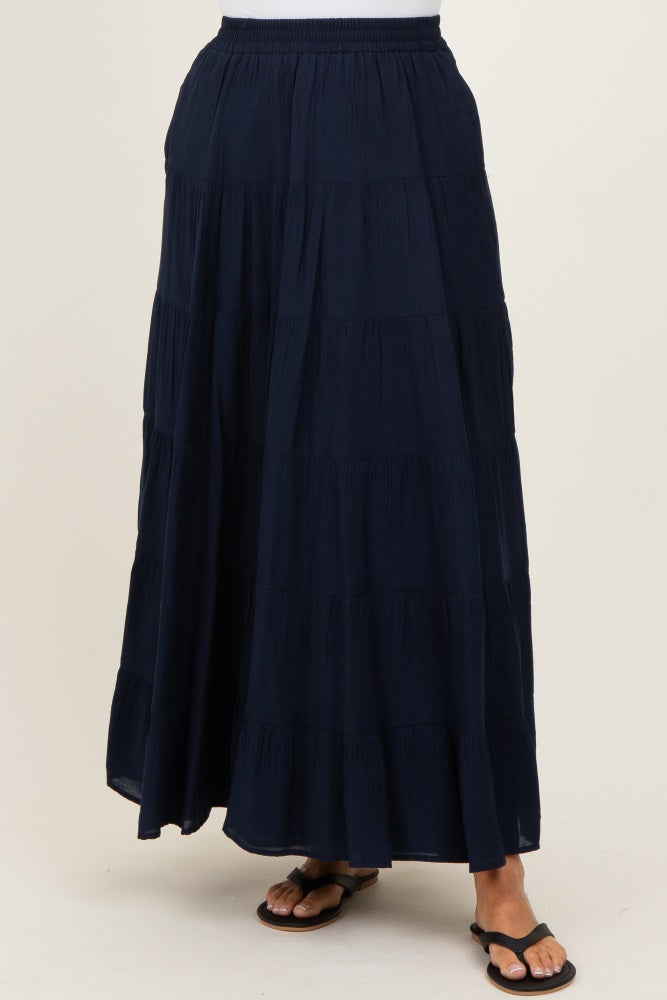 woman wearing a navy blue tiered maxi skirt with an elastic waistband and flat sandals