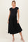 woman wearing a black maternity dress with a fitted top and a flowy skirt, accessorized with a belt and standing confidently