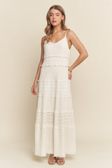 woman wearing a white tiered maxi dress with spaghetti straps and a textured design